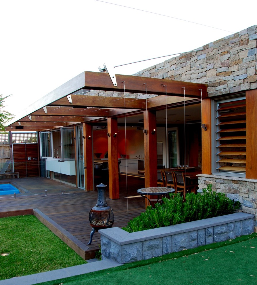 Idées déco pour une terrasse en bois arrière contemporaine de taille moyenne avec un foyer extérieur et une pergola.