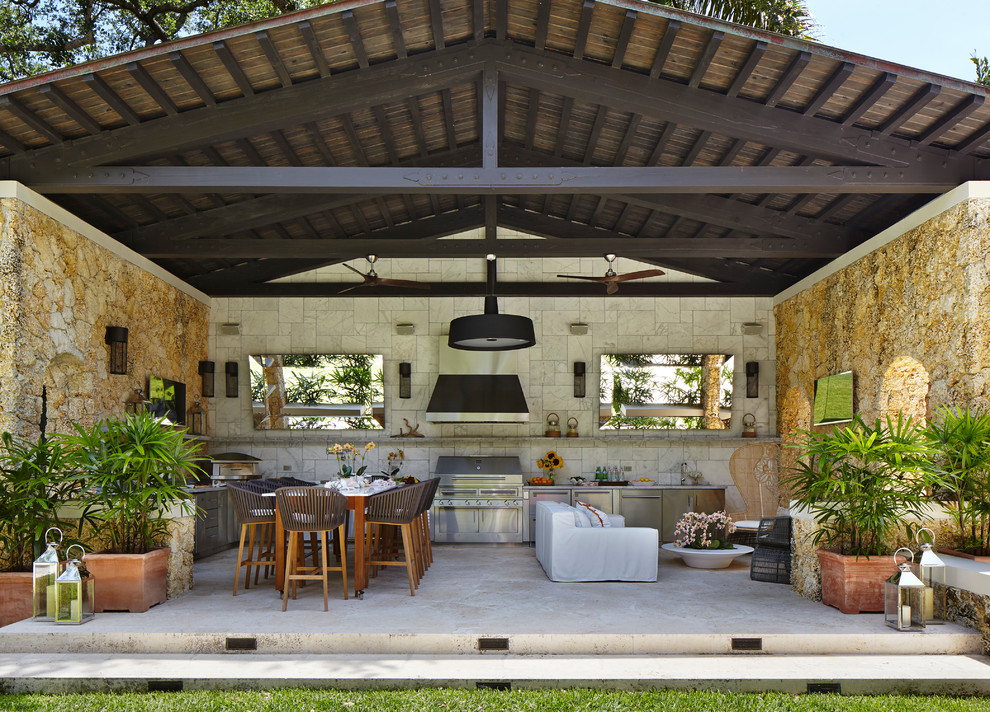 Ispirazione per un patio o portico mediterraneo con pavimentazioni in pietra naturale e un tetto a sbalzo