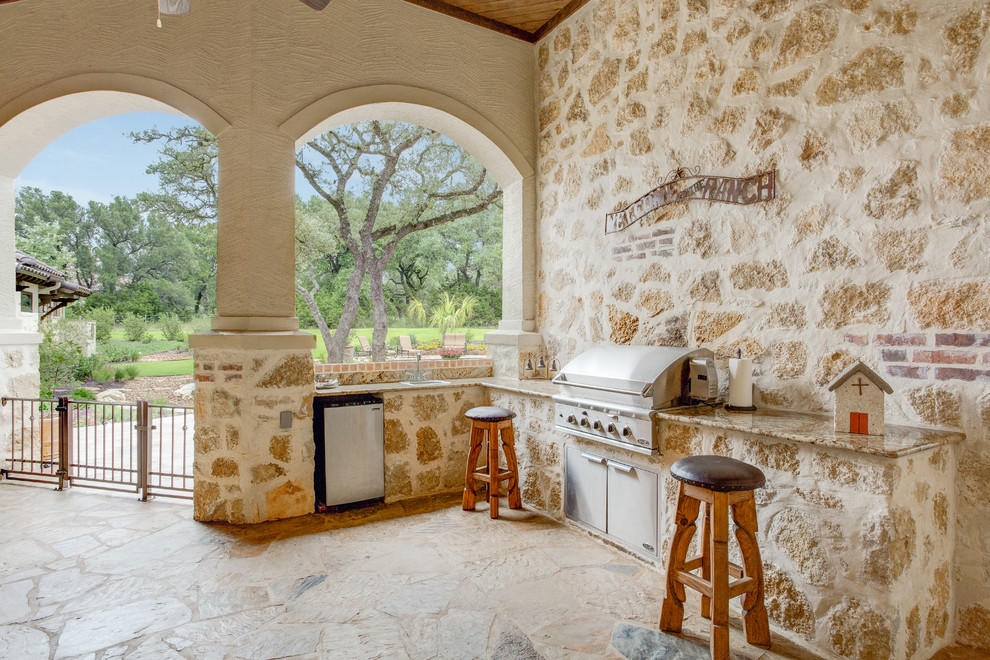Überdachter Mediterraner Patio hinter dem Haus mit Natursteinplatten und Grillplatz in Austin