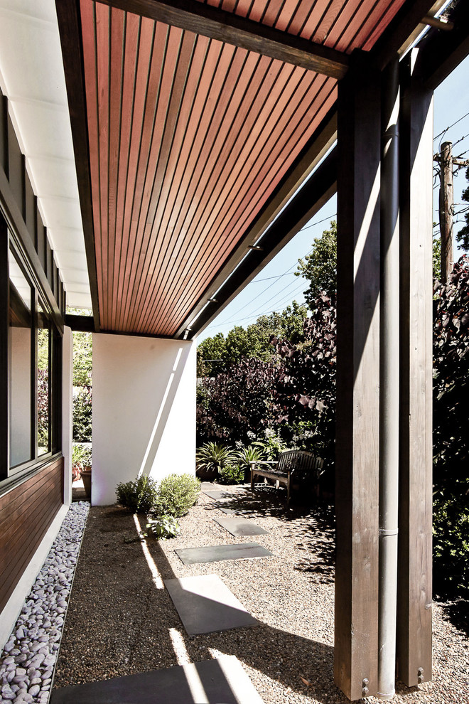 Inspiration pour une terrasse arrière design avec des pavés en pierre naturelle et aucune couverture.