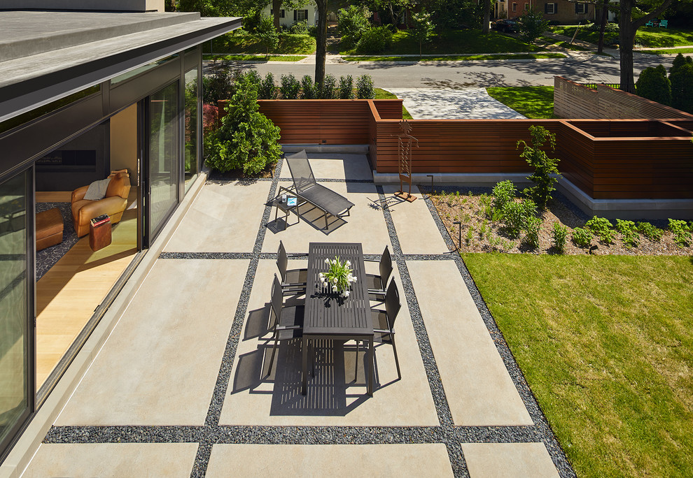 На фото: двор среднего размера на заднем дворе в современном стиле с покрытием из бетонных плит без защиты от солнца