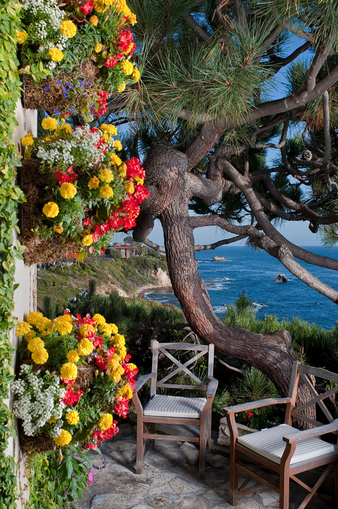 Idee per un grande patio o portico costiero dietro casa con pavimentazioni in pietra naturale e nessuna copertura