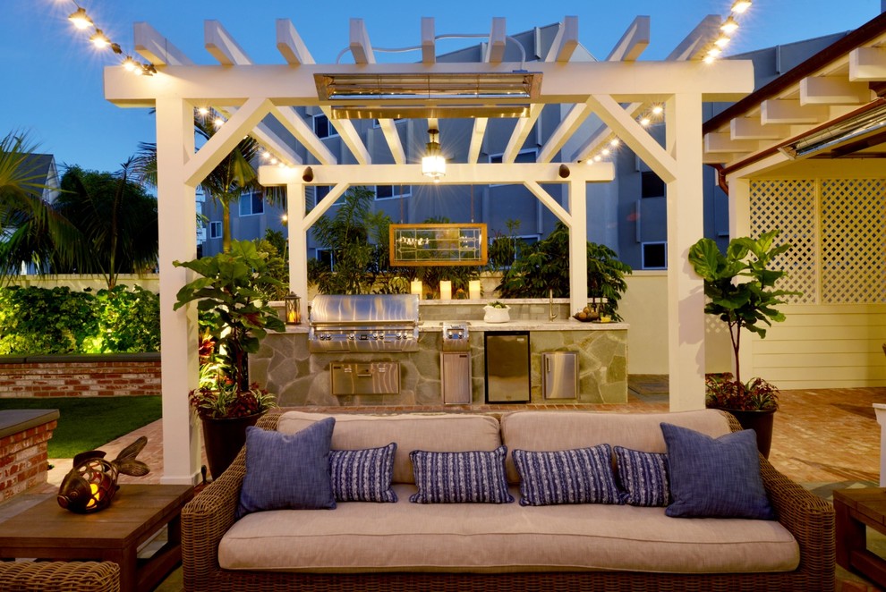 Immagine di un piccolo patio o portico stile marino dietro casa con pavimentazioni in mattoni e una pergola