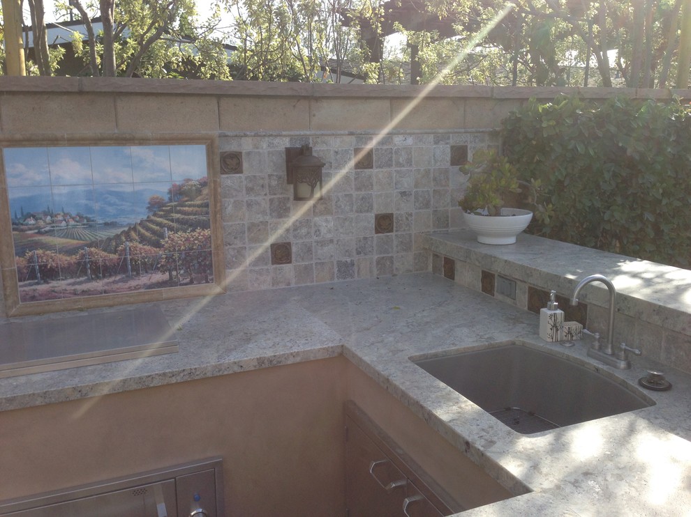 Ejemplo de patio mediterráneo de tamaño medio en patio trasero con cocina exterior, adoquines de hormigón y cenador