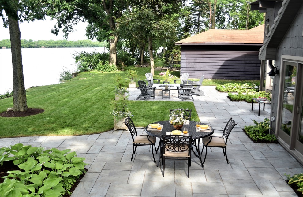 Immagine di un patio o portico chic di medie dimensioni e dietro casa con un focolare e pavimentazioni in cemento