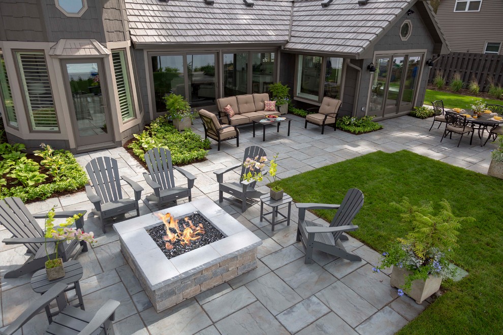 Imagen de patio de estilo americano de tamaño medio sin cubierta en patio trasero con brasero y adoquines de hormigón