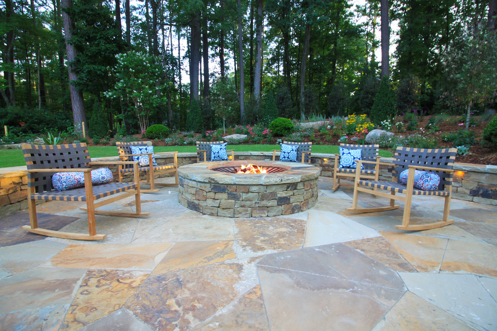 Ejemplo de patio rústico sin cubierta en patio trasero con brasero y adoquines de piedra natural