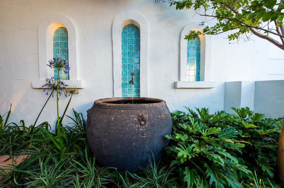 На фото: маленький двор на внутреннем дворе в средиземноморском стиле с фонтаном для на участке и в саду