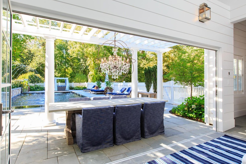 Inspiration for a large timeless backyard concrete paver patio remodel in New York with a pergola