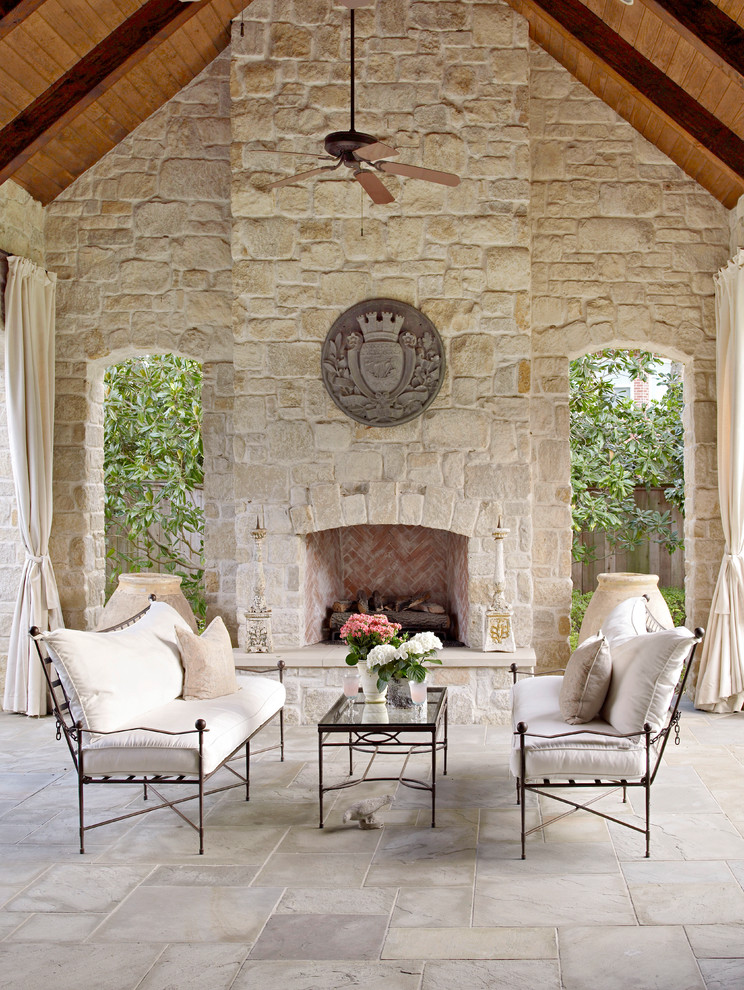 Design ideas for a back patio in Houston with natural stone paving, a roof extension and a fireplace.