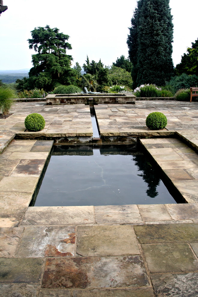 Klassischer Patio mit Wasserspiel und Natursteinplatten in Hampshire