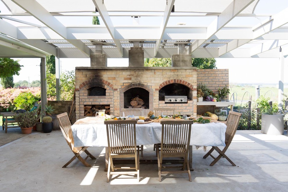 Foto de patio campestre grande con cocina exterior, losas de hormigón y pérgola