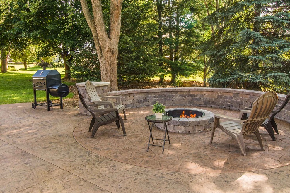 Inspiration for a large timeless backyard stamped concrete patio remodel in Other with a fire pit and no cover