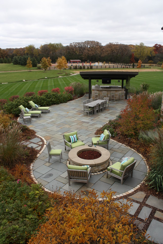 Immagine di un grande patio o portico country dietro casa con pavimentazioni in pietra naturale e un gazebo o capanno