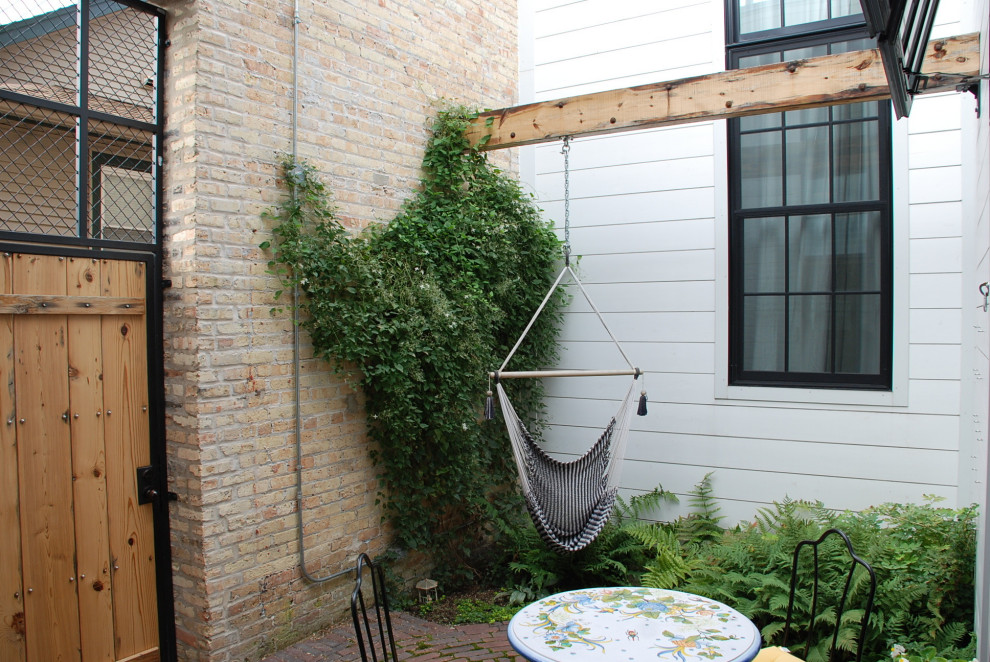 Идея дизайна: двор на внутреннем дворе с вертикальным садом и мощением клинкерной брусчаткой без защиты от солнца