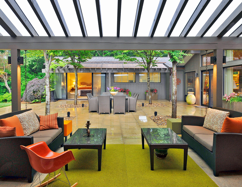 Immagine di un patio o portico minimal in cortile con pavimentazioni in cemento e un tetto a sbalzo