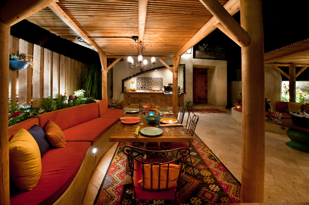 Foto di un ampio patio o portico eclettico dietro casa con pavimentazioni in pietra naturale e una pergola