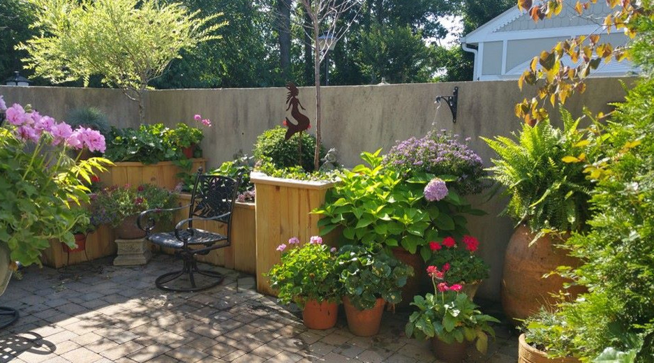 Пример оригинального дизайна: маленький двор на внутреннем дворе в стиле фьюжн с растениями в контейнерах и мощением тротуарной плиткой без защиты от солнца для на участке и в саду