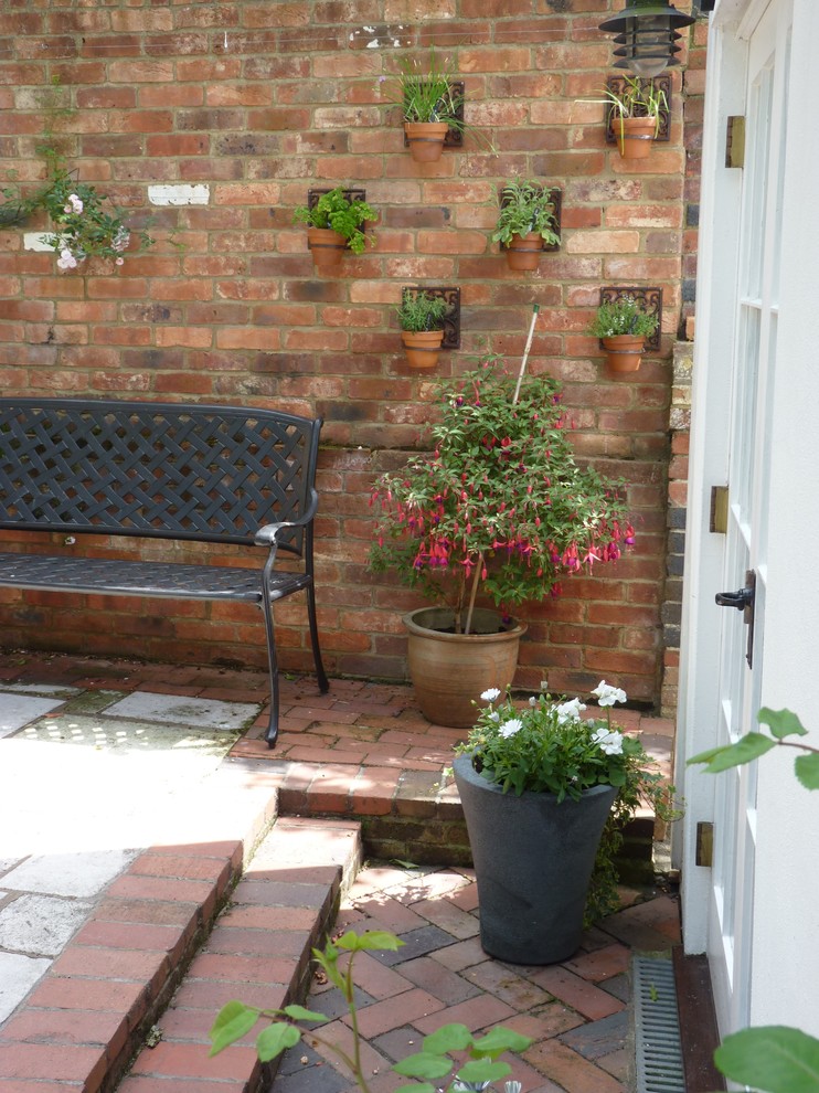 Design ideas for a classic patio in Sussex with brick paving.