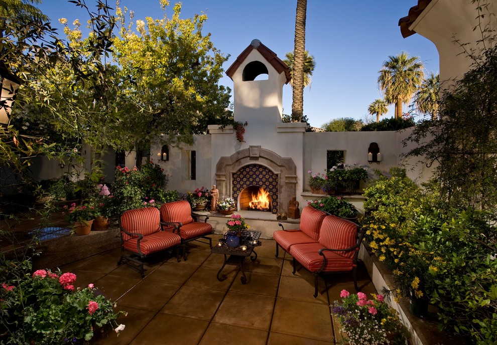 Photo of a medium sized mediterranean back patio in Phoenix with a fire feature, concrete paving and no cover.