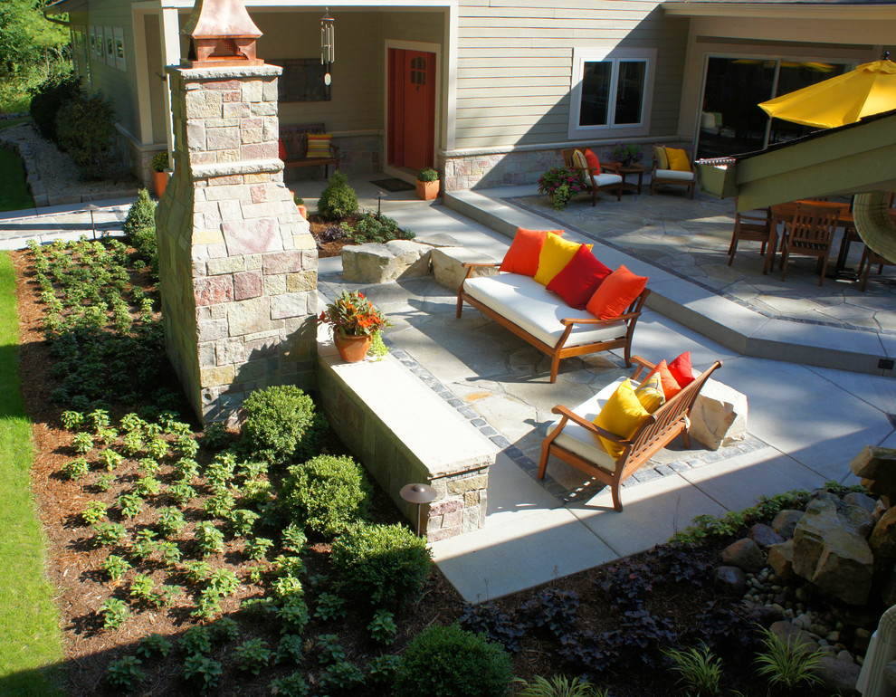 Diseño de patio contemporáneo de tamaño medio sin cubierta en patio trasero con brasero y adoquines de piedra natural