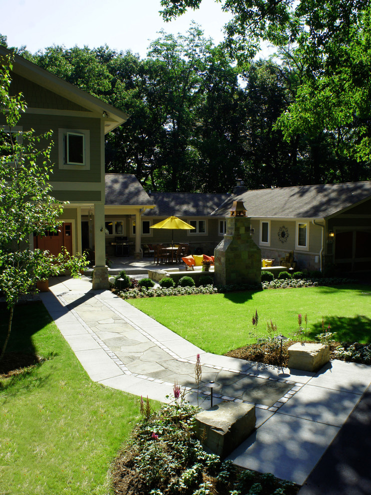 Imagen de patio actual de tamaño medio sin cubierta en patio trasero con brasero y adoquines de piedra natural