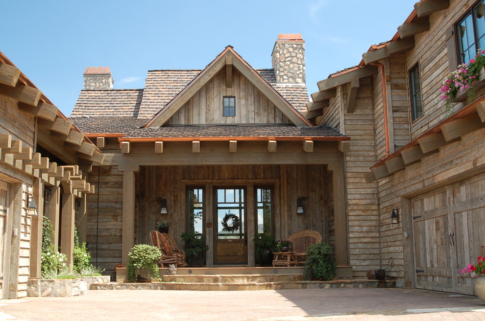 Immagine di un ampio patio o portico contemporaneo in cortile con un giardino in vaso, pavimentazioni in pietra naturale e un tetto a sbalzo