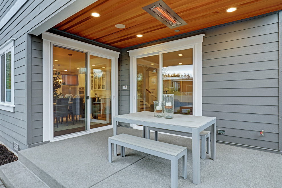 Idee per un patio o portico american style dietro casa con lastre di cemento e un tetto a sbalzo
