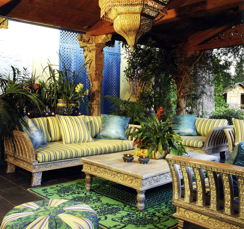Idee per un patio o portico tropicale di medie dimensioni e dietro casa con piastrelle e un tetto a sbalzo