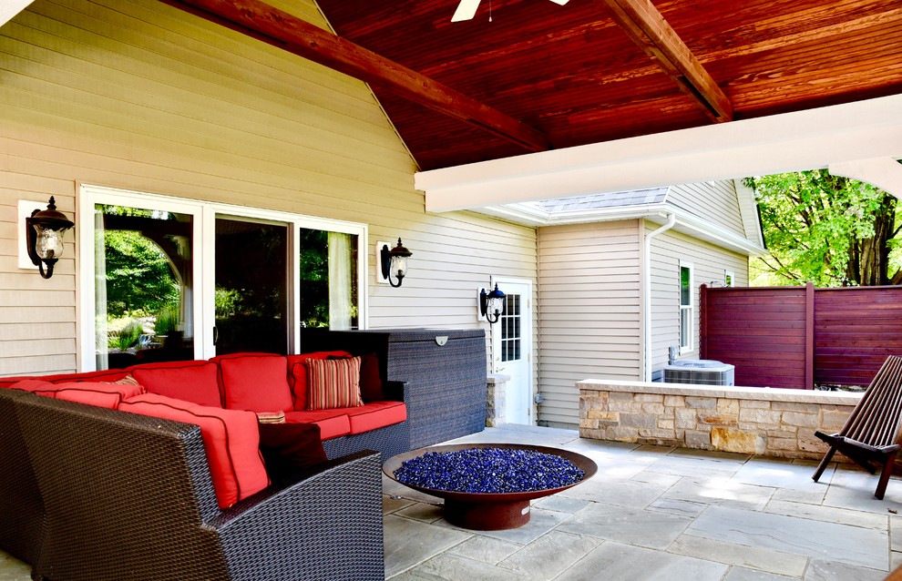 Ispirazione per un grande patio o portico stile americano dietro casa con un focolare, cemento stampato e un tetto a sbalzo