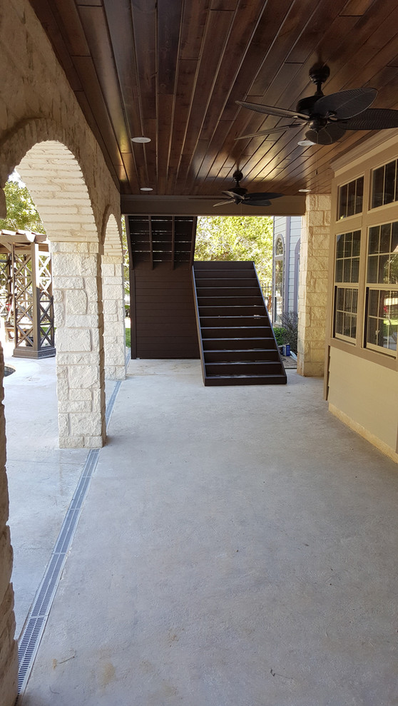 This is an example of a medium sized contemporary side patio in Austin with concrete slabs and a roof extension.