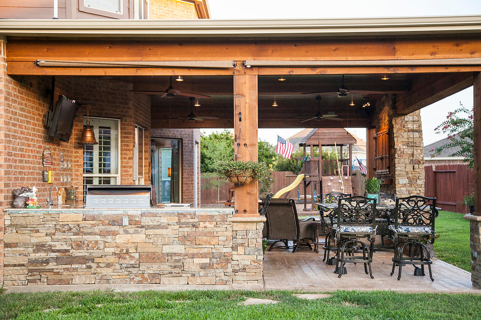 Immagine di un patio o portico rustico di medie dimensioni e dietro casa con cemento stampato e un tetto a sbalzo
