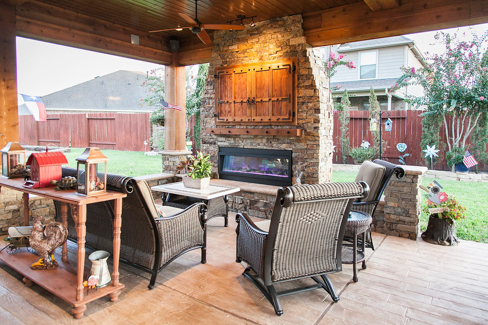 Photo of a medium sized rustic back patio in Houston with an outdoor kitchen, stamped concrete and a roof extension.