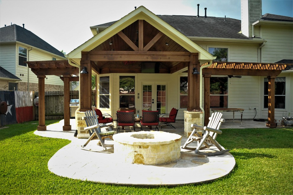 Foto di un patio o portico tradizionale di medie dimensioni e dietro casa con un focolare, cemento stampato e una pergola