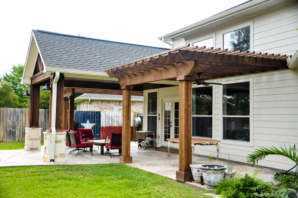 Esempio di un patio o portico tradizionale di medie dimensioni e dietro casa con un focolare, cemento stampato e una pergola