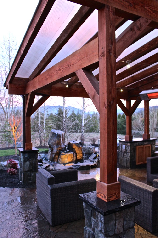 Ejemplo de patio de estilo americano de tamaño medio en patio trasero con adoquines de hormigón y cenador