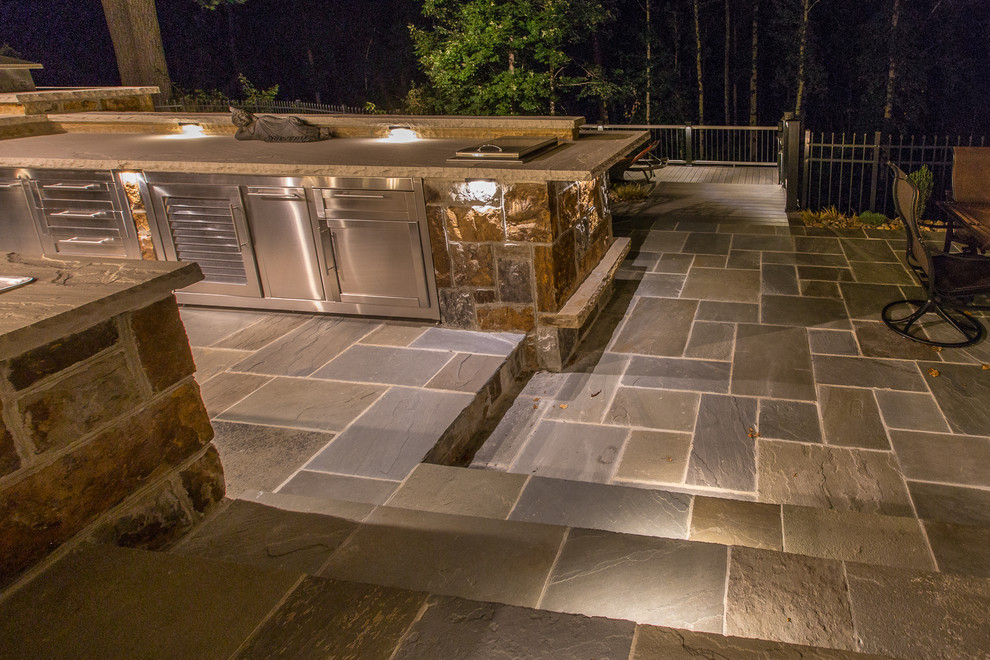 Idées déco pour une grande terrasse arrière moderne avec une cuisine d'été et des pavés en pierre naturelle.