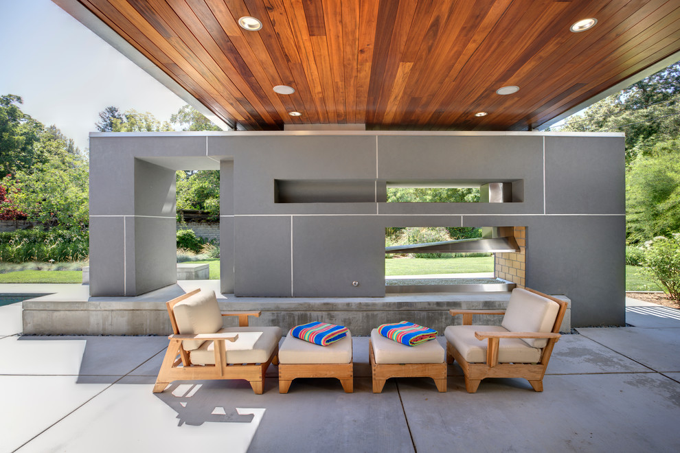 Réalisation d'une terrasse design avec un foyer extérieur.