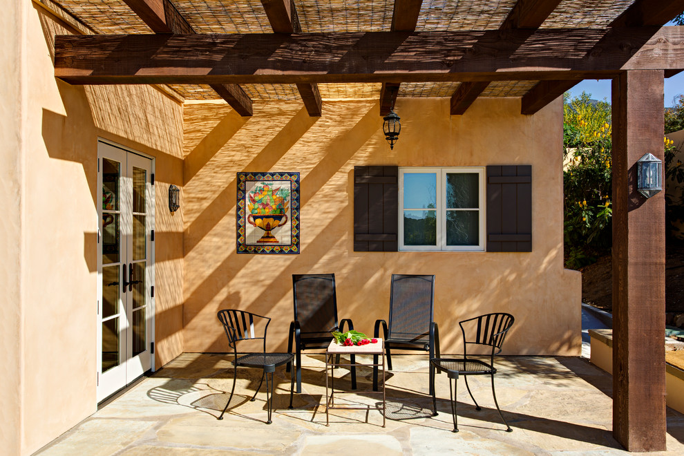 Photo of a mediterranean side patio in Santa Barbara with tiled flooring and a pergola.