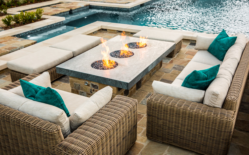 Inspiration for a large contemporary back patio in Orange County with a fire feature, natural stone paving and no cover.