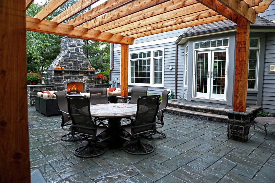 Inspiration pour une grande terrasse arrière traditionnelle avec une cuisine d'été, du béton estampé et une pergola.