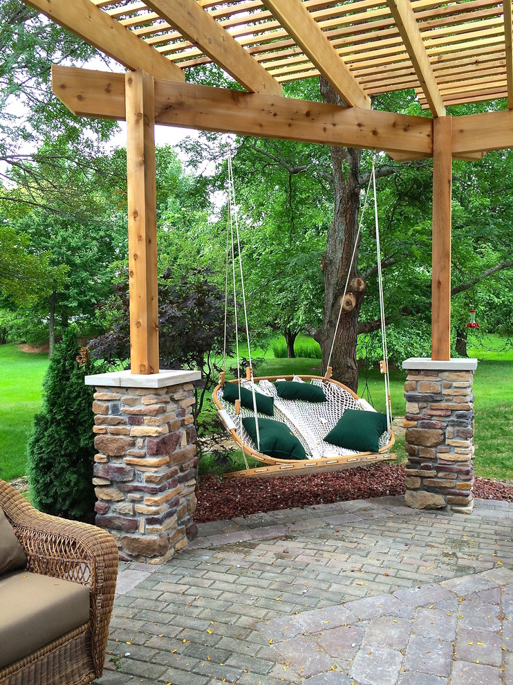 Diseño de patio clásico de tamaño medio en patio trasero con jardín de macetas, adoquines de piedra natural y pérgola