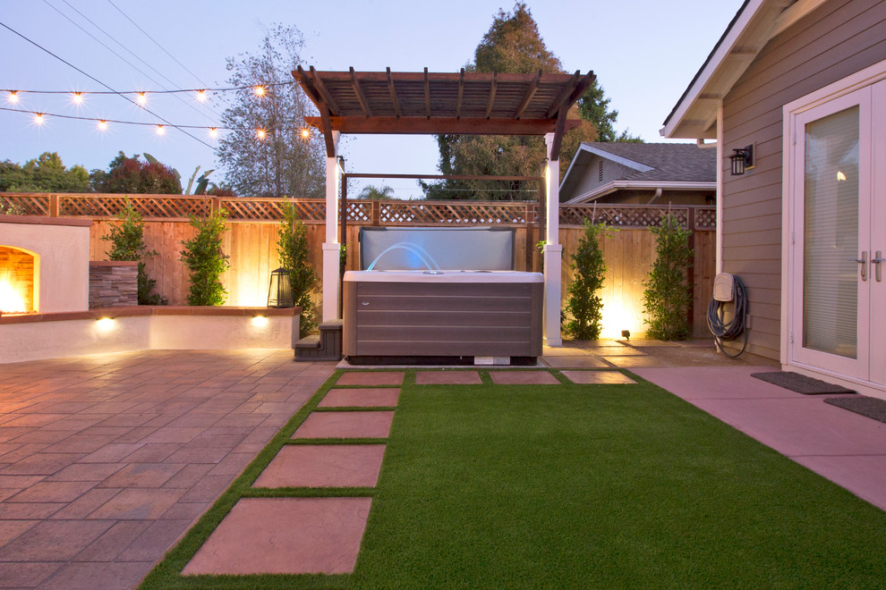 Esempio di un piccolo patio o portico american style dietro casa con un caminetto, pavimentazioni in cemento e una pergola