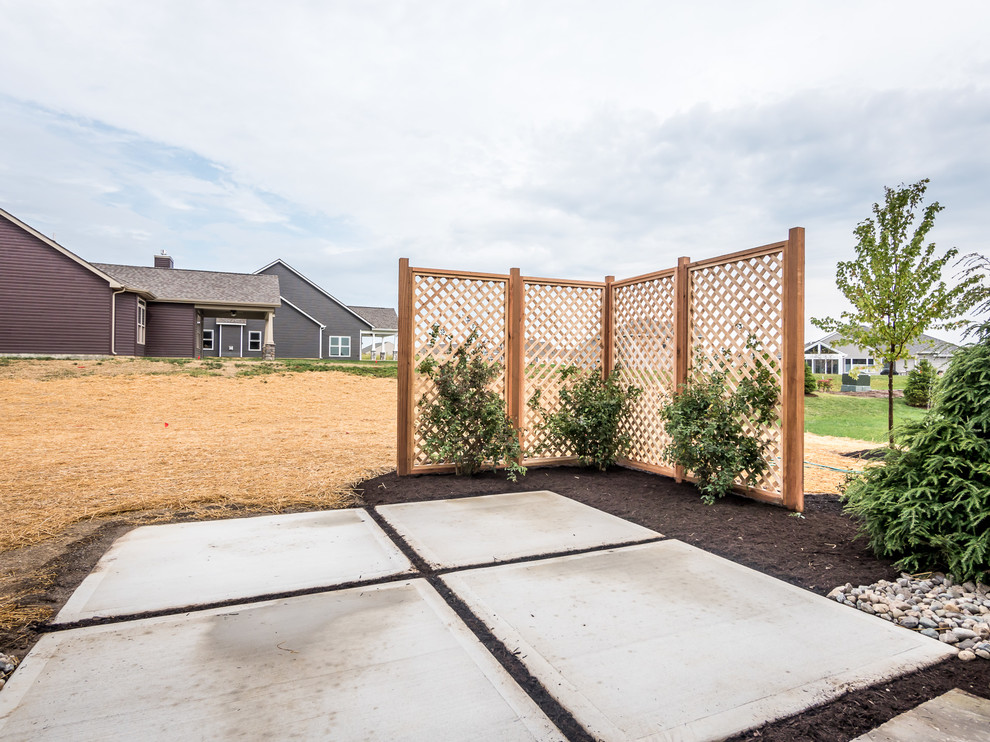 Diseño de patio rústico grande sin cubierta en patio trasero con losas de hormigón
