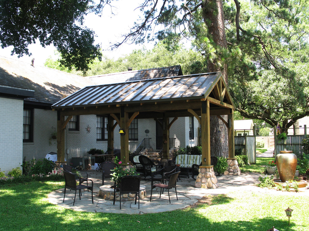 Ejemplo de patio de estilo americano de tamaño medio en patio trasero con adoquines de piedra natural y toldo