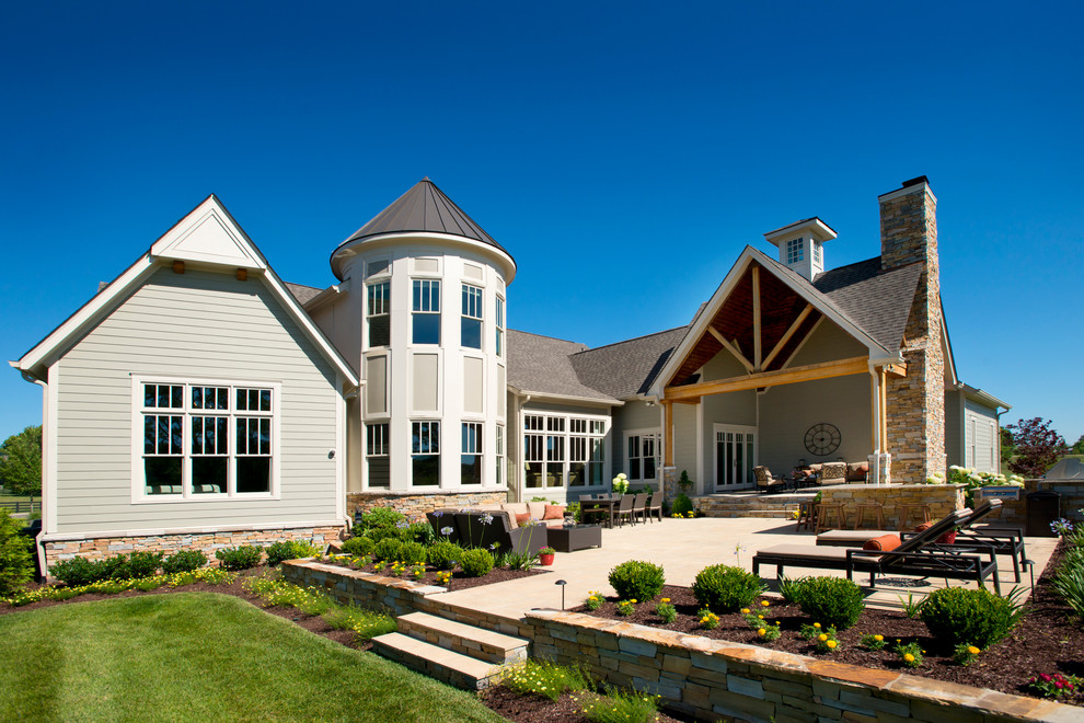 Immagine di un patio o portico american style dietro casa con pavimentazioni in pietra naturale e un tetto a sbalzo