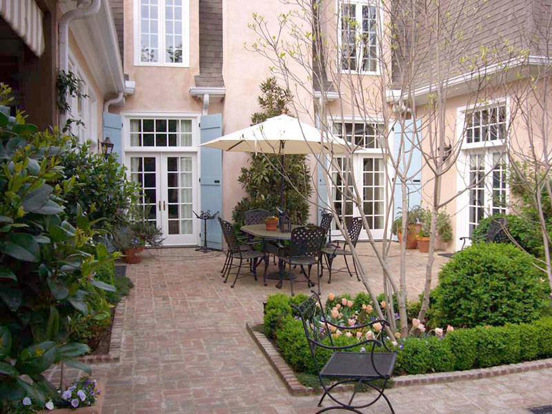 Mid-sized elegant courtyard brick patio photo in Other