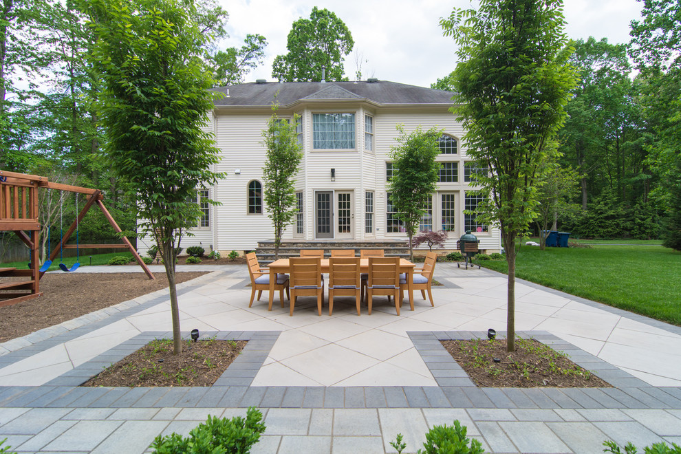 Immagine di un grande patio o portico classico dietro casa con pavimentazioni in pietra naturale e nessuna copertura