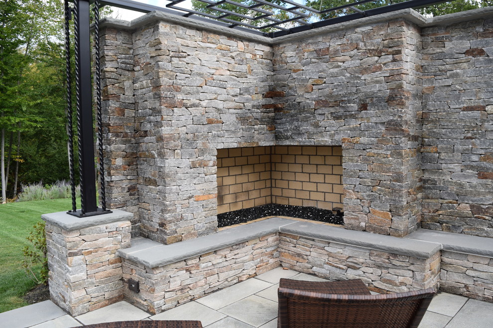 Foto di un grande patio o portico minimalista dietro casa con fontane, pavimentazioni in pietra naturale e una pergola