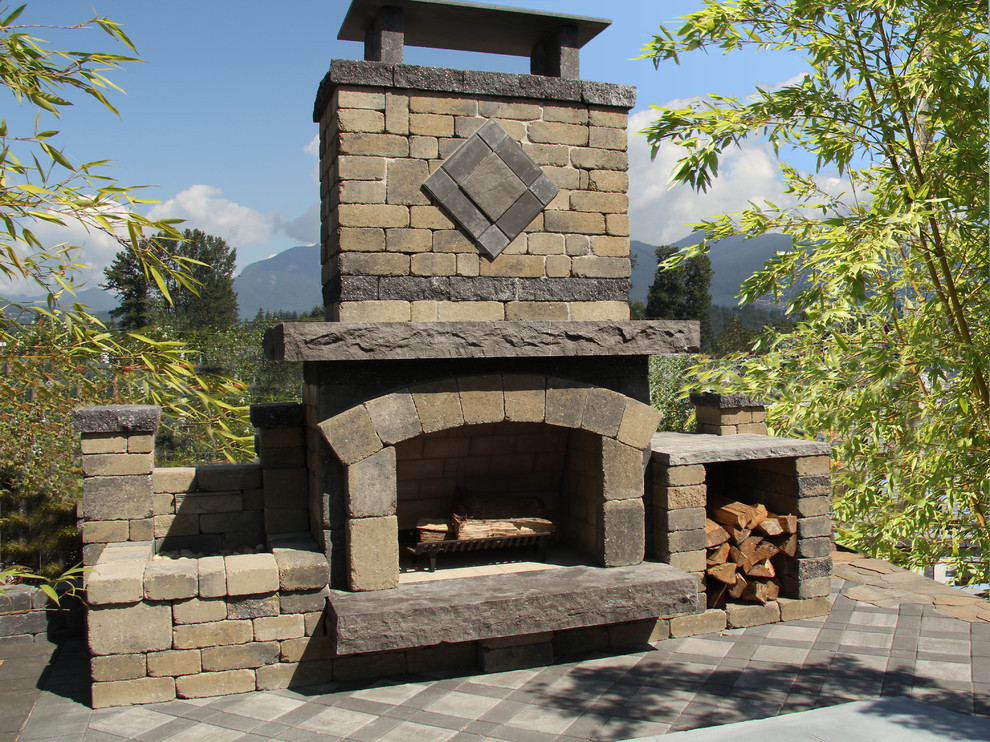 Large rustic back patio in Vancouver with a fire feature, concrete paving and no cover.